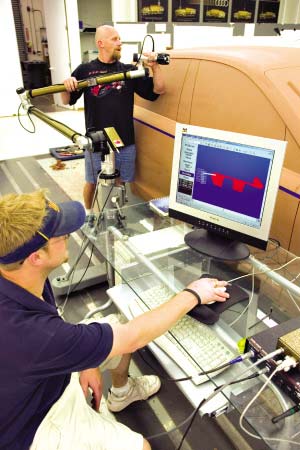 模具师在利用激光设备检测油泥模型与设计数据是否吻合