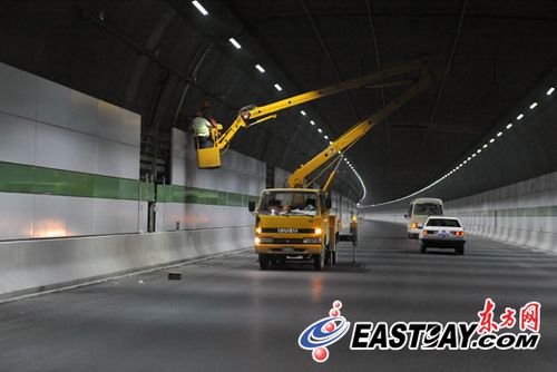 上海长江隧道内，工人正在对墙面进行铺装。