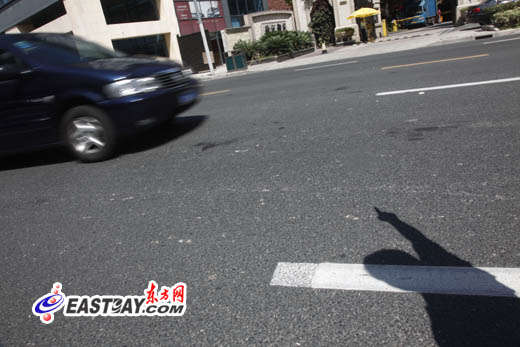 图片说明：目击者向记者指出当时事发情形，现场仍留有血迹。